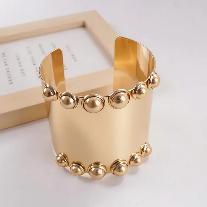 Bracelet large à clous dorés, bijou audacieux et moderne pour brunch, rendez-vous et tenues élégante